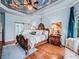 Luxurious bedroom featuring a custom-painted sky ceiling, ornate wood furnishings, and a sliding barn door to the en suite bathroom at 7060 Summit Ridge Chase, Cumming, GA 30041