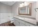 A full bathroom features a large framed mirror, granite countertops, and tile bath surround at 840 United Avenue Southeast # 401, Atlanta, GA 30312