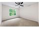 Bright bedroom features a ceiling fan and a large window overlooking the green outdoors at 89 Prospect Path, Hiram, GA 30141