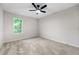 Cozy carpeted bedroom with a ceiling fan and a bright window offering natural light at 89 Prospect Path, Hiram, GA 30141