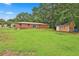 Expansive backyard view featuring lush greenery surrounding the brick home and wooden storage shed at 191 Pine Ne St, Fairburn, GA 30213