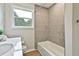 Cozy bathroom featuring a vanity with solid countertop and tub with tiled surround at 191 Pine Ne St, Fairburn, GA 30213