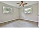Well-lit bedroom with two windows, ceiling fan, and wood-look flooring at 191 Pine Ne St, Fairburn, GA 30213