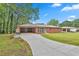Long driveway leading to a brick home with an attached carport, showcasing curb appeal at 191 Pine Ne St, Fairburn, GA 30213