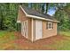 A charming wooden storage shed featuring white trim, double doors and decorative shutters at 191 Pine Ne St, Fairburn, GA 30213