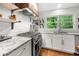 Well-lit kitchen featuring stainless steel appliances, granite countertops, subway tile backsplash, and a bright window at 2020 New Kemp Rd, Marietta, GA 30066