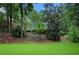 View of backyard with gentle slope from manicured lawn to property line at 386 Link Rd, Alpharetta, GA 30022