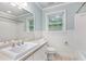 Bright bathroom with a sink, vanity, toilet, tiled floor, and a window providing natural light at 386 Link Rd, Alpharetta, GA 30022
