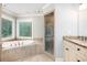 Bright bathroom features a soaking tub, glass-enclosed shower, and granite vanity at 386 Link Rd, Alpharetta, GA 30022