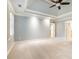 Carpeted bedroom features tray ceiling, fan, and white shutters for a bright and airy feel at 386 Link Rd, Alpharetta, GA 30022