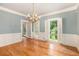 Light-filled dining room with hardwood floors, wainscotting, and a chandelier at 386 Link Rd, Alpharetta, GA 30022