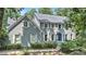 Charming two-story brick home with gray siding, white shutters, and mature landscaping during the day at 386 Link Rd, Alpharetta, GA 30022