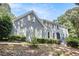 Charming two-story brick home with gray siding, white shutters, and mature landscaping during the day at 386 Link Rd, Alpharetta, GA 30022