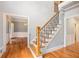 Spacious foyer with hardwood floors, staircase with black iron spindles, and views into the living and dining rooms at 386 Link Rd, Alpharetta, GA 30022