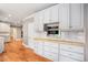 Modern kitchen with white cabinets, stainless steel appliances, and hardwood floors at 386 Link Rd, Alpharetta, GA 30022