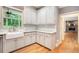 Bright kitchen features a farmhouse sink, white cabinets, and granite countertops with hardwood flooring at 386 Link Rd, Alpharetta, GA 30022