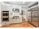 Gourmet kitchen with stainless steel appliances, white cabinetry, and hardwood floors at 386 Link Rd, Alpharetta, GA 30022