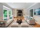 Bright living room with stone fireplace, built-in bookshelves, hardwood floors, and large bay windows at 386 Link Rd, Alpharetta, GA 30022