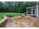 Stone patio with a decorative fire pit and seating area overlooking the backyard at 386 Link Rd, Alpharetta, GA 30022