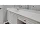 Bathroom vanity with a white countertop, white cabinets, sink, and ample storage space at 11280 Brookhollow Trl, Alpharetta, GA 30022