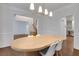 An open-concept dining room flowing to other living spaces, hardwood floors, and white wainscotting at 11280 Brookhollow Trl, Alpharetta, GA 30022