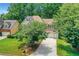 Suburban home with lush green lawn, mature trees, and a driveway with a basketball hoop for outdoor fun at 11280 Brookhollow Trl, Alpharetta, GA 30022