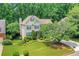 Two-story home boasting a well-kept lawn, mature trees, and an inviting facade with classic dark shutters at 11280 Brookhollow Trl, Alpharetta, GA 30022