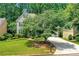 Two-story home with mature landscaping, a green lawn, and an inviting driveway, perfect for families at 11280 Brookhollow Trl, Alpharetta, GA 30022