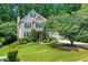 Charming two-story home featuring a well-manicured lawn, lush landscaping, and a classic facade with dark shutters at 11280 Brookhollow Trl, Alpharetta, GA 30022