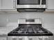 Close-up of gas range, showing stainless steel and sleek design of modern kitchen appliance at 11280 Brookhollow Trl, Alpharetta, GA 30022