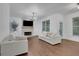 Living room featuring hardwood floors, a stone fireplace, built-in shelving, and abundant natural light at 11280 Brookhollow Trl, Alpharetta, GA 30022