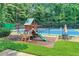 Close-up of a playground with a slide, swings, and a tennis court behind a chain-link fence at 11280 Brookhollow Trl, Alpharetta, GA 30022