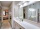 Bright bathroom featuring a long vanity, large mirror, and bedroom access at 1875 Skidmore Cir, Lawrenceville, GA 30044