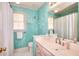 Blue bathroom featuring a vanity with a large mirror and a shower with a curtain at 1875 Skidmore Cir, Lawrenceville, GA 30044