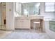 Bathroom featuring a soaking tub, separate shower, and vanity with makeup area and chair at 1875 Skidmore Cir, Lawrenceville, GA 30044
