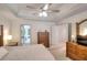 Large, light-filled bedroom boasts tray ceilings, ceiling fan, and access to an en-suite bathroom at 1875 Skidmore Cir, Lawrenceville, GA 30044