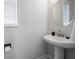 Clean and bright bathroom features a pedestal sink, round mirror and natural light at 3322 Cranston Ln, Kennesaw, GA 30144
