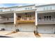 Townhome exterior with garages, back patios, wood railings, and neutral color scheme. Modern design at 3322 Cranston Ln, Kennesaw, GA 30144