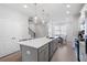 Spacious kitchen featuring an island, stainless steel appliances, with adjacent dining area and view of the staircase at 3322 Cranston Ln, Kennesaw, GA 30144