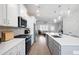 A modern kitchen with white countertops, stainless steel appliances, and a view leading into an airy, naturally lit living area at 3322 Cranston Ln, Kennesaw, GA 30144