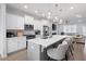 A modern kitchen with white cabinets, stainless steel appliances, a large island with pendant lighting, and an adjacent living area at 3322 Cranston Ln, Kennesaw, GA 30144