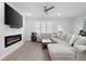 Well-lit living room features a large sectional sofa, modern fireplace, and wall-mounted television at 3322 Cranston Ln, Kennesaw, GA 30144