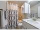 Bathroom features tile shower with decorative curtain, a white vanity and a white toilet at 4104 Townsend Ln, Dunwoody, GA 30346