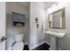 Stylish half bathroom with pedestal sink, decorative mirror, and modern fixtures at 4104 Townsend Ln, Dunwoody, GA 30346
