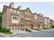 A row of brick townhomes with attached garages on a tree lined street at 4104 Townsend Ln, Dunwoody, GA 30346
