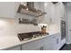 Modern kitchen featuring white cabinets, stainless steel range hood, and gas cooktop at 4104 Townsend Ln, Dunwoody, GA 30346