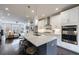 Open kitchen features island with seating, modern stainless appliances, and flows into living area at 4104 Townsend Ln, Dunwoody, GA 30346