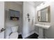 Chic powder room featuring a pedestal sink, decorative mirror and a modern aesthetic at 4104 Townsend Ln, Dunwoody, GA 30346