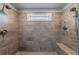 A modern bathroom shower featuring dual shower heads, tiled walls, a built-in bench, and a window for natural light at 4104 Townsend Ln, Dunwoody, GA 30346