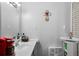 Functional bathroom featuring a sink, mirror, and small storage, accented with decorative cross at 5839 Darry Cir, Norcross, GA 30093